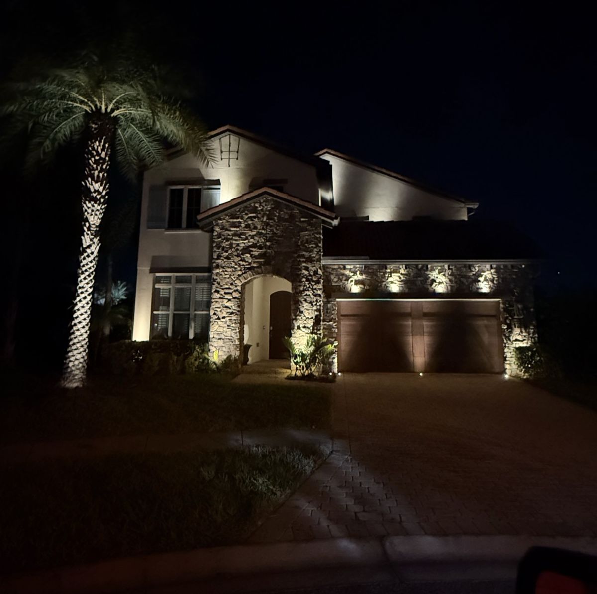 Royal Cypress Preserve Orlando luxury home with natural stone facade and warm white architectural LED uplighting by LED Artistry