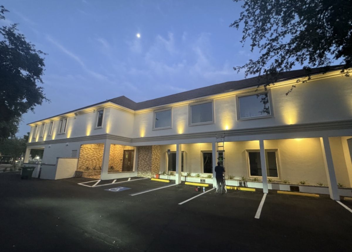 Two story professional office building with warm white LED architectural uplighting at dusk