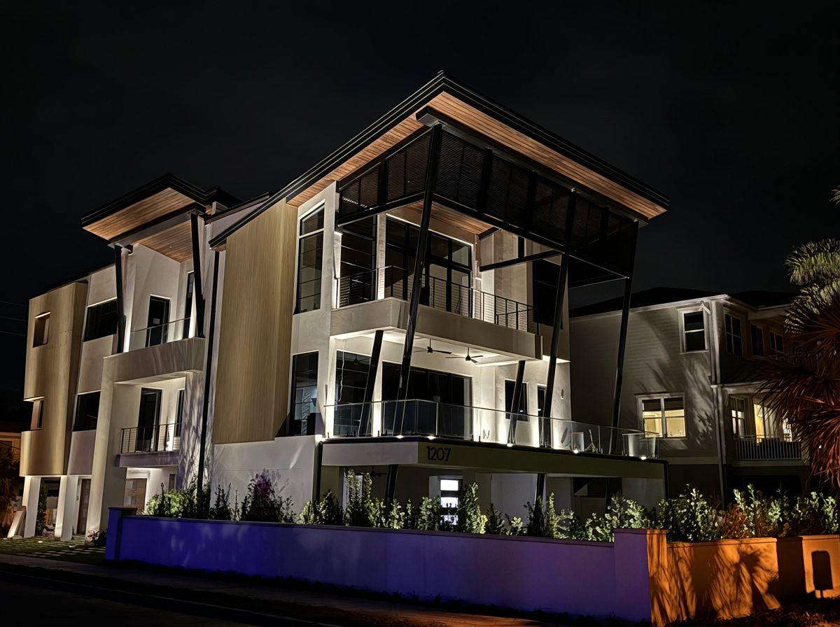 Mediterranean luxury estate at dusk with warm LED uplighting on arches and columns