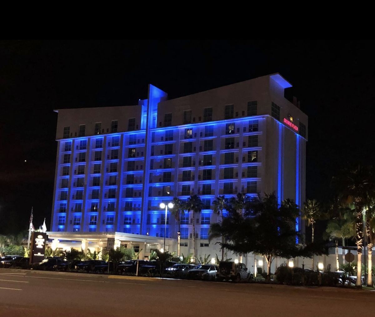 Hotel Alba Tampa formerly Crowne Plaza full exterior at night — RGBW blue facade wash across all 11 stories, porte-cochère, and landscape uplighting by LED Artistry