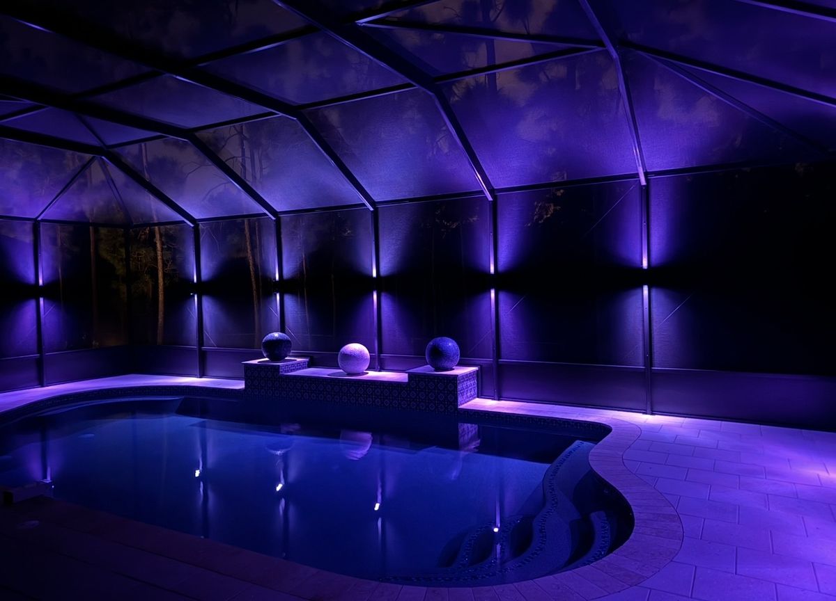Pool cage with electric blue RGBW LED color lighting at night, pool glowing blue Tampa Bay
